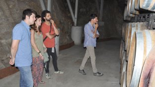 Mireia Pujol-Busquets, d'Alta Alella, mostra la sala de barriques a Alegret, Barceló i Costa.