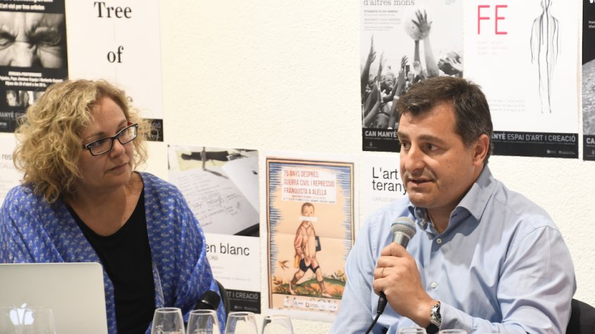 Josep "Pitu" Roca durant una de les seves intervencions, sota  l'atenta mirada de Montserrat Serra
