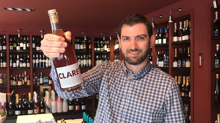 L'Enric Espinosa mostra, orgullós, una de les ampolles de Claret que ja té a la venda al seu establiment