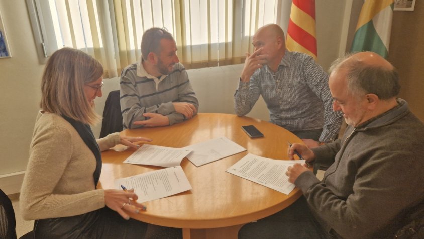Colomé i Ruiz durant la signatura. Al fons, Òscar Pallarès, director de la revista, i Josep Casals, regidor de Promoció Econòmica